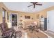 Living room featuring couch, leather chair, mini refrigerator, and ceiling fan at 36801 N Long Rifle Rd, Carefree, AZ 85377