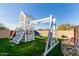 Backyard wooden playset with slide and climbing wall on a lush green lawn area at 36801 N Long Rifle Rd, Carefree, AZ 85377
