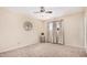 Bright bedroom with light neutral walls, modern ceiling fan, and natural light from the large window at 3814 W El Camino Dr, Phoenix, AZ 85051