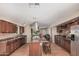 Spacious kitchen with dark wood cabinets, granite counters, an island with bar seating, and stainless steel appliances at 3814 W El Camino Dr, Phoenix, AZ 85051