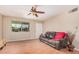 Comfortable living room featuring a ceiling fan, wood flooring, and a leather sofa for relaxation at 3814 W El Camino Dr, Phoenix, AZ 85051