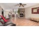 Open-concept living area boasts a fireplace, laminate floors and views into the kitchen and dining room at 3814 W El Camino Dr, Phoenix, AZ 85051