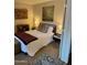 Well-lit bedroom features a cozy carpet, comfy queen bed and decorative wall art at 4303 E Cactus Rd # 235, Phoenix, AZ 85032