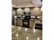 Updated kitchen featuring granite countertops, gray cabinets, stainless steel appliances and tile flooring at 4303 E Cactus Rd # 235, Phoenix, AZ 85032
