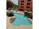 Beautiful swimming pool features lounge chairs, rock waterfall and lush green landscape at 4303 E Cactus Rd # 235, Phoenix, AZ 85032