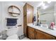 Bright bathroom featuring a vanity, mirror and an ample wooden cabinet at 4323 W Rose Ln, Glendale, AZ 85301