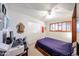 Neutral bedroom with a ceiling fan, closet, and a window with shutters at 4323 W Rose Ln, Glendale, AZ 85301