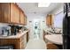 Efficient kitchen with wood cabinetry, compact appliances, and adjacent dining area at 4323 W Rose Ln, Glendale, AZ 85301
