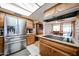 Kitchen with wooden cabinets, laminate flooring, stainless steel refrigerator, and access to dining room at 4323 W Rose Ln, Glendale, AZ 85301