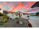 A wide shot of the house, yard, and pool at sunset with a view of the mountains at 5822 N 44Th Pl, Phoenix, AZ 85018