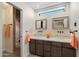 Bright bathroom featuring dual glass vessel sinks, modern fixtures, and decorative accents at 5822 N 44Th Pl, Phoenix, AZ 85018
