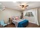 Charming bedroom with a floral bedspread, ceiling fan, and a cozy seating area, offering a peaceful and inviting ambiance at 5822 N 44Th Pl, Phoenix, AZ 85018