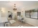 Bright dining area featuring a chandelier and views of the outdoor pool through large windows, creating an inviting space at 5822 N 44Th Pl, Phoenix, AZ 85018