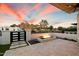 Outdoor fire pit with travertine tile, drought-tolerant landscaping, and black iron fence at 5822 N 44Th Pl, Phoenix, AZ 85018
