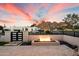Outdoor fire pit featuring travertine tile, drought-tolerant landscaping, and a view of the desert mountain at 5822 N 44Th Pl, Phoenix, AZ 85018