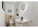 Stylish half-bathroom featuring a modern round mirror and unique decor, adding a touch of elegance to the space at 5822 N 44Th Pl, Phoenix, AZ 85018