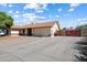 Wide driveway leading to the attached garage with adjacent wood fence and well-maintained landscaping at 6614 S Mckemy St, Tempe, AZ 85283