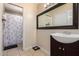 Well-lit bathroom featuring a dark vanity and a shower with decorative curtain at 6926 W Comet Ave, Peoria, AZ 85345