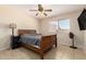 Bedroom with natural light, ceiling fan, wood bed frame, and tile flooring at 6926 W Comet Ave, Peoria, AZ 85345