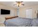 Comfortable bedroom with ceiling fan, mounted television, and neutral walls at 6926 W Comet Ave, Peoria, AZ 85345