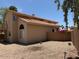 View of back yard featuring desert landscaping, privacy fence, and two-story home at 7702 W Piute Ave, Glendale, AZ 85308