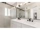Bathroom with double sink vanity, quartz countertop, and walk-in shower with black hardware at 7702 W Piute Ave, Glendale, AZ 85308