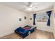 Bright bedroom with a ceiling fan, wood floors, large window, and themed decor at 7702 W Piute Ave, Glendale, AZ 85308