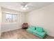 Bright bedroom with light wood floors, a plush sofa, and large windows at 7702 W Piute Ave, Glendale, AZ 85308