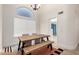 Bright dining area featuring a large window, modern chandelier and wood flooring at 7702 W Piute Ave, Glendale, AZ 85308