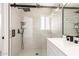 Walk-in shower featuring rain shower head, handheld wand, and tiled walls at 7702 W Piute Ave, Glendale, AZ 85308