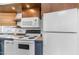 Bright kitchen featuring white appliances and wood cabinets, and a window with blinds for light and privacy at 838 Aquamarine Dr, Apache Junction, AZ 85119