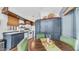 Open-concept kitchen with green chairs, dark-wood cabinets, appliances, and wood-style floors at 838 Aquamarine Dr, Apache Junction, AZ 85119