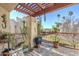Open-air balcony with pergola cover, potted plants, and decorative wall art at 9275 E Mission Ln # 206, Scottsdale, AZ 85258