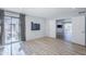 Living room with laminate flooring, large windows, balcony, and double doors at 9275 E Mission Ln # 206, Scottsdale, AZ 85258