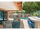 Relaxing back patio with a gas fire bar, wicker seating, pool views, and a beautiful neutral outdoor rug at 10838 N 10Th St, Phoenix, AZ 85020