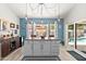 Modern kitchen island with gray cabinetry, striking light fixture, and seamless access to the outdoor pool at 10838 N 10Th St, Phoenix, AZ 85020