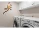 Laundry room featuring full size washer and dryer, overhead cabinets, and neutral color scheme at 10838 N 10Th St, Phoenix, AZ 85020