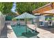 Backyard pool with lounge chair, umbrella, patio seating, and an outdoor bar at 10838 N 10Th St, Phoenix, AZ 85020