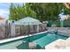 The backyard pool features a lounge chair in the water and an umbrella for shade at 10838 N 10Th St, Phoenix, AZ 85020
