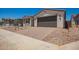 New construction home with dark garage door, tile roof, desert landscaping, and brick driveway at 11408 S 50Th Ln, Laveen, AZ 85339
