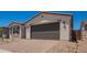 The two-car garage of this charming single-story home sits on a brick paver drive at 11408 S 50Th Ln, Laveen, AZ 85339