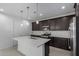 This is a gourmet kitchen with an island, stainless steel appliances, and dark cabinets with pendant lights at 11408 S 50Th Ln, Laveen, AZ 85339