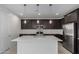 Modern kitchen features stainless steel appliances, espresso cabinetry, a white island, and stylish pendant lighting at 11408 S 50Th Ln, Laveen, AZ 85339