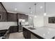 Gourmet kitchen with stainless appliances, dark cabinetry, pendant lighting, and an island for seating at 11408 S 50Th Ln, Laveen, AZ 85339