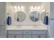 Bathroom featuring dual vanity sinks, modern lighting fixtures and bright white counters and cabinets at 116 E Santa Lucia Ln, Queen Creek, AZ 85140