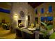 Comfortable outdoor living space with a stone fireplace, comfortable seating, and ambient lighting at 116 E Santa Lucia Ln, Queen Creek, AZ 85140