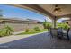 This covered patio features a dining set, green turf, and peaceful views at 116 E Santa Lucia Ln, Queen Creek, AZ 85140