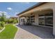 Relax on this covered patio with a ceiling fan, stylish chairs, and lush landscaping at 116 E Santa Lucia Ln, Queen Creek, AZ 85140