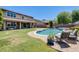 Inviting backyard showcases a shimmering pool, lush greenery, and an outdoor seating area for relaxation at 11875 W Lone Tree Trl, Peoria, AZ 85383