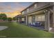 Outdoor living space with covered patio, ceiling fans, and a TV overlooking the spacious grassy backyard at 11875 W Lone Tree Trl, Peoria, AZ 85383